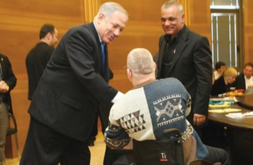 Binyamin Netanyahu shakes hands with a disabled veteran 370 (photo credit: Ariel Jerozolimski)