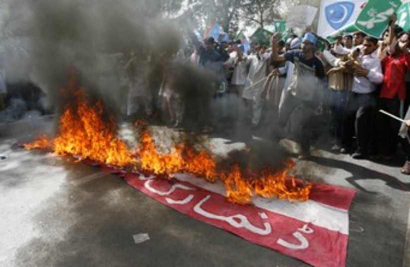Pakistanis burn a Danish flag 370 [file] (photo credit: REUTERS/Mohsin Raza)