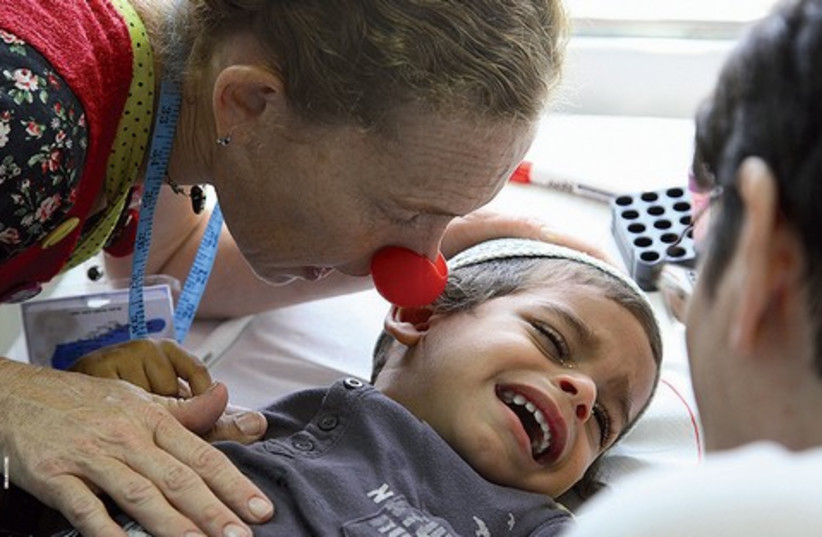 Fifi comforts a young patient 521 (photo credit: Dream Doctors)