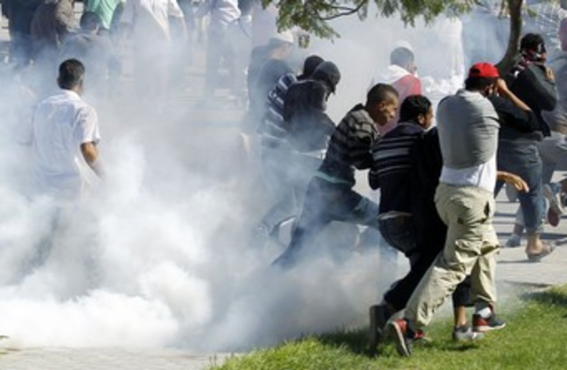 Protesters run for cover outside US Embassy in Tunis 390 (R) (photo credit: Zoubeir Souissi / Reuters)