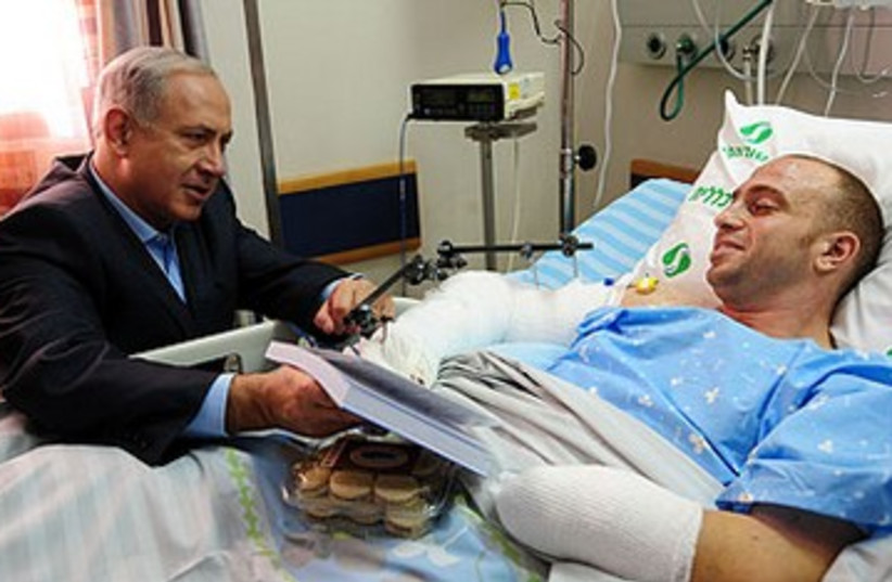 Netanyahu visits wounded IDF officer 390 (photo credit: GPO)