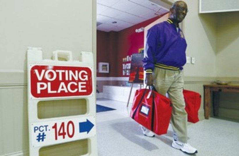 Bill Partlow carries voting supplies in Pineville 370 (photo credit: Reuters)