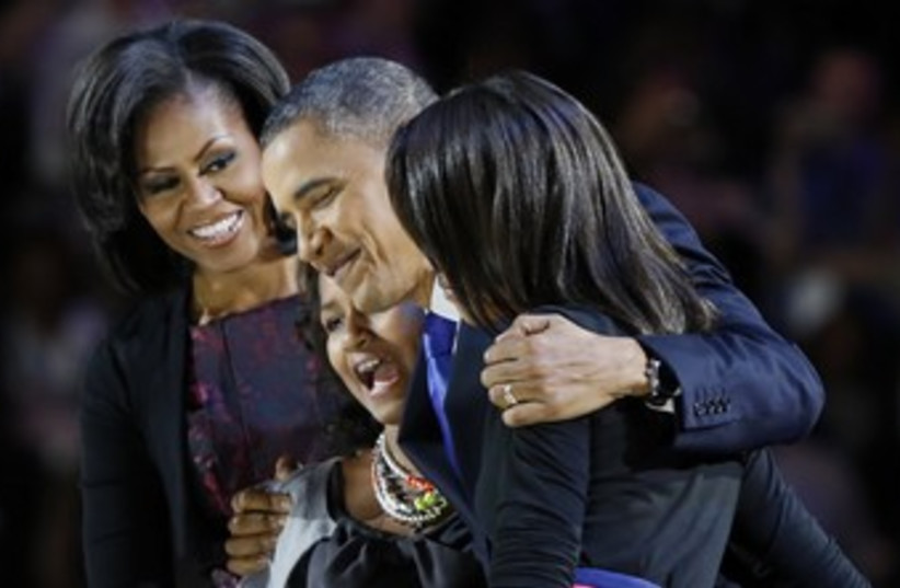 Obama hugs his family after winning re-election 370 (R) (photo credit: Larry Downing / Reuters)
