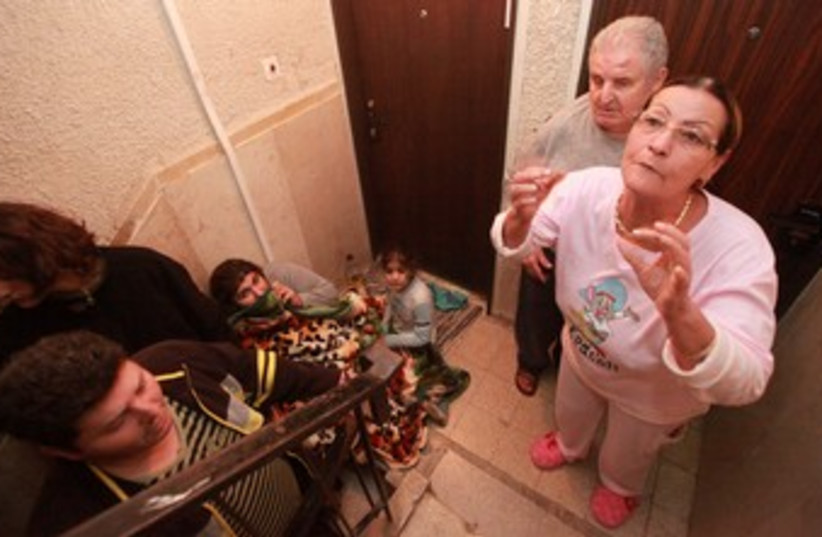 Beersheba residents take shelter in a stairwell 370 (photo credit: Marc Israel Sellem / The Jerusalem Post)