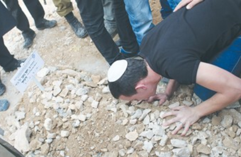MOURNER kisses the grave of Cpl. Yosef Fartuk 370 (photo credit: Marc Israel Sellem/The Jerusalem Post)