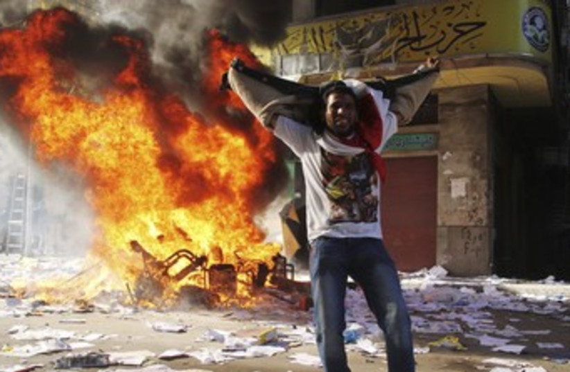 Protester cheers as Egypt's Brotherhood office ransacked 370 (photo credit: REUTERS)