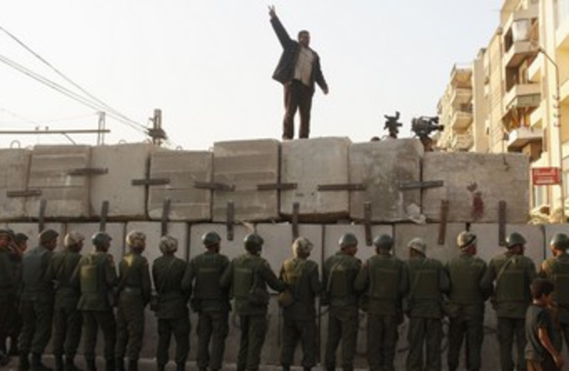 Egyptian protester on barrier surrounding palace 370 (photo credit: REUTERS/Asmaa Waguih)