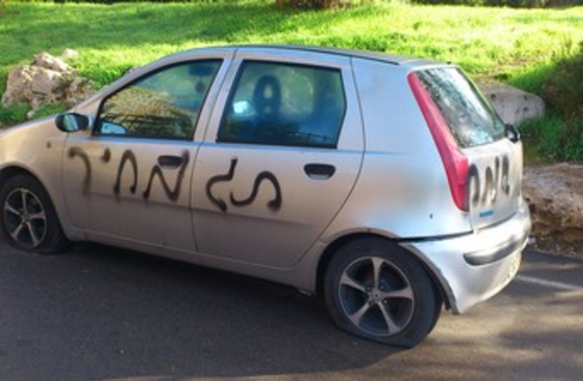 Car with punctured tires, "price tag" graffiti [File] (photo credit: Melanie Lidman)