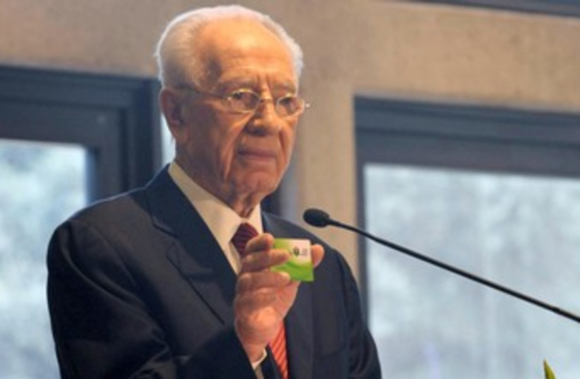 President Peres holding ADI card 370 (photo credit: Mark Neyman/GPO)