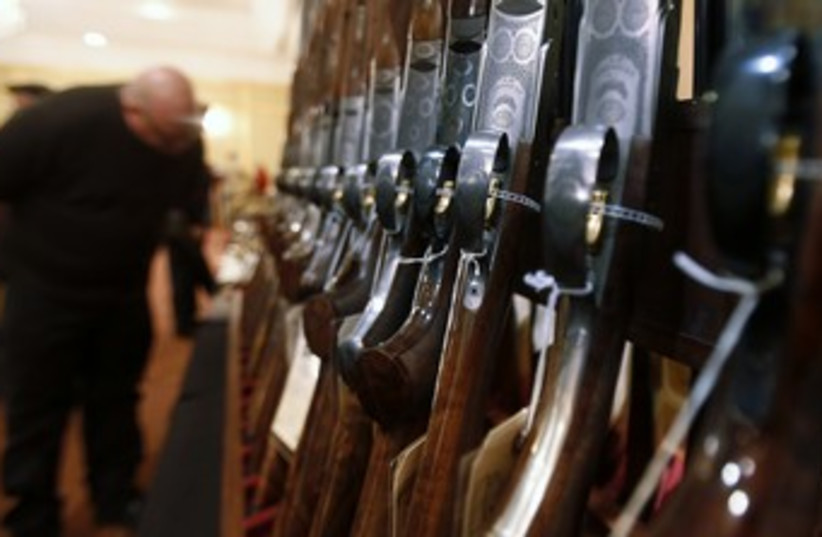 Man looks at shotguns in Connecticut 370 (photo credit: REUTERS/Carlo Allegri)