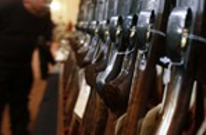 Man looks at shotguns in Connecticut 150 (photo credit: REUTERS/Carlo Allegri)