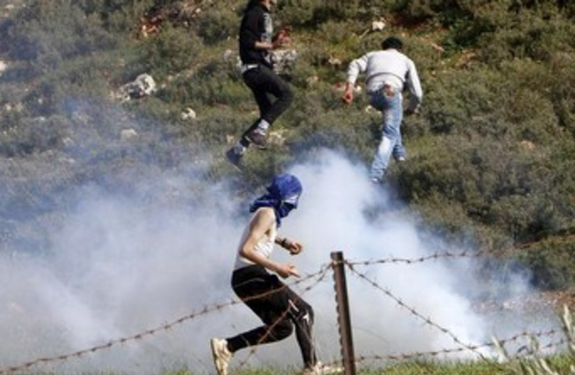 Palestinians flee tear gas 370 (photo credit: REUTERS)