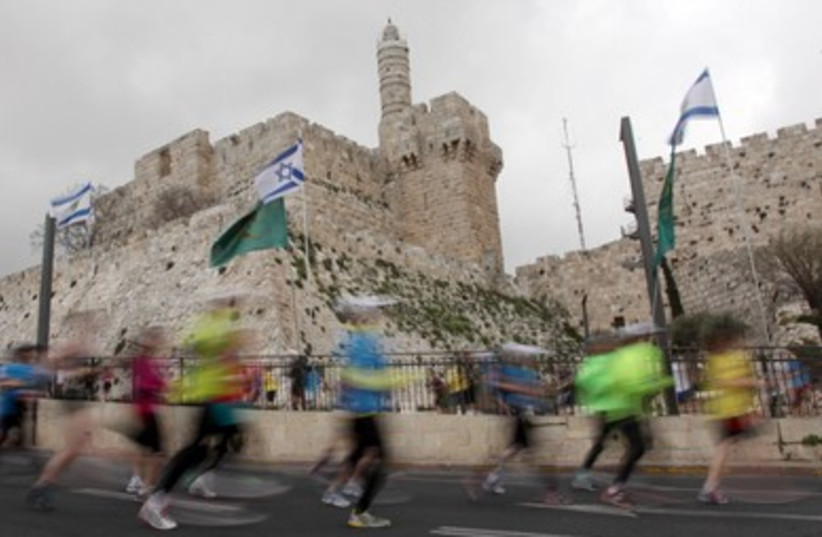 Runners sprint past the Tower of David in the Old City 