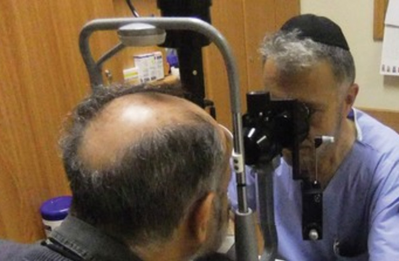 Eye doctor examines patient 370 (photo credit: Judy Siegel-Itzkovich)