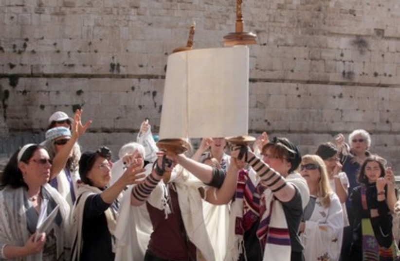 Women unravel a Torah scroll together at the Western Wall