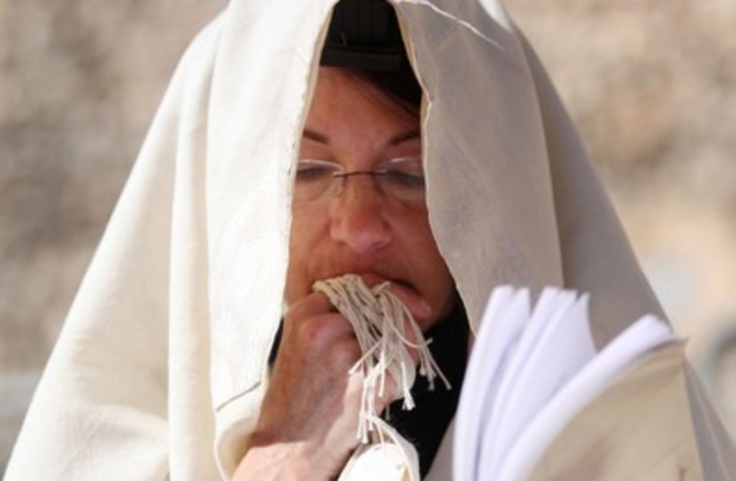 A woman prays in a prayer shawl at the Western Wall