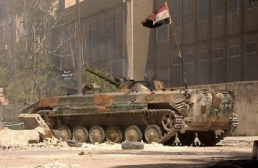 A Syrian Army tank bearing a Syrian national flag 370 (photo credit: REUTERS/George Ourfalian )