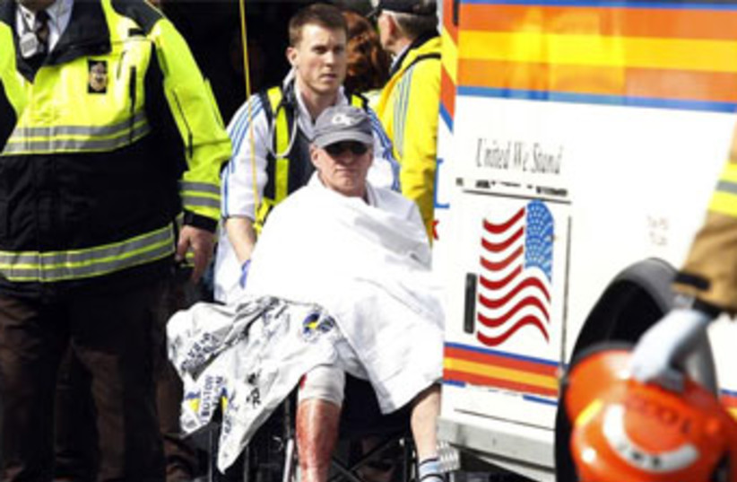 A runner is wheeled from a triage tent after twin blasts at the Boston Marathon, April 15, 2013.