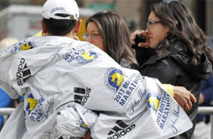 People comfort each other after deadly twin blasts at the Boston Marathon, April 15, 2013. 