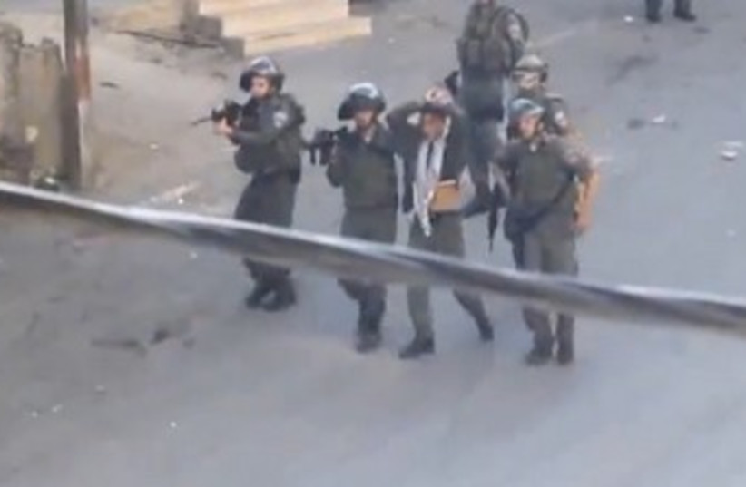 Officers with bound Palestinian teen 370 (photo credit: YouTube Screenshot)