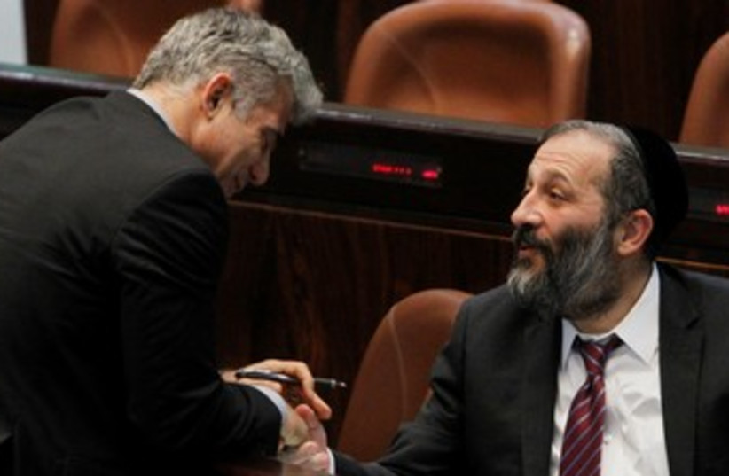 Lapid shaking hands with Deri at Knesset 370 (photo credit: Marc Israel Sellem/The Jerusalem Post)