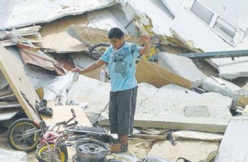 Beduin boy on rubble of demolished house 370 (photo credit: Wikimedia Commons)