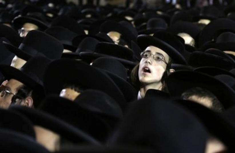 Haredi boy peers out of crowd 