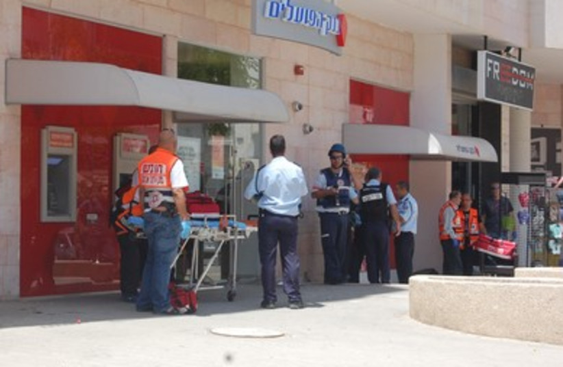 Police and EMS workers outside Beersheba bank where shooting took place, May 20, 2013