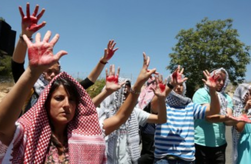 Israelis wearing keffiyehs protest prisoner release 370 (photo credit: Marc Israel Sellem/The Jerusalem Post)