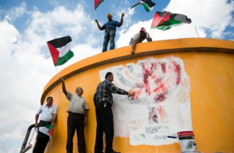 Palestinians wave flags on ruins of settlement 370 (photo credit: Yesh Din)