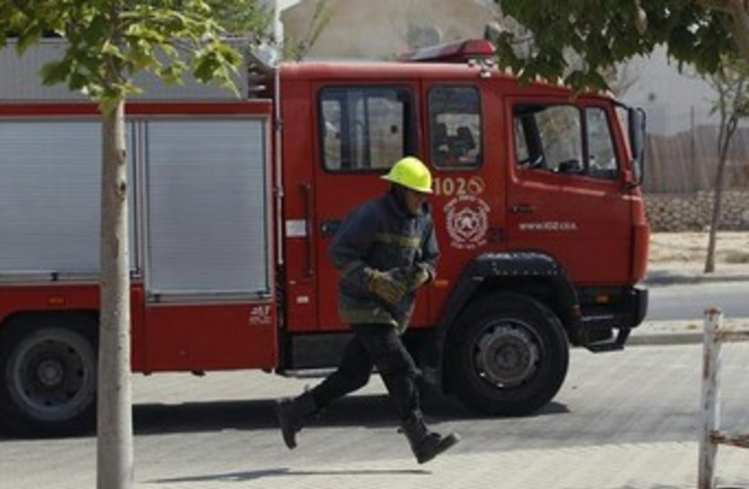 firefighter and firetruck 370 (photo credit: REUTERS)