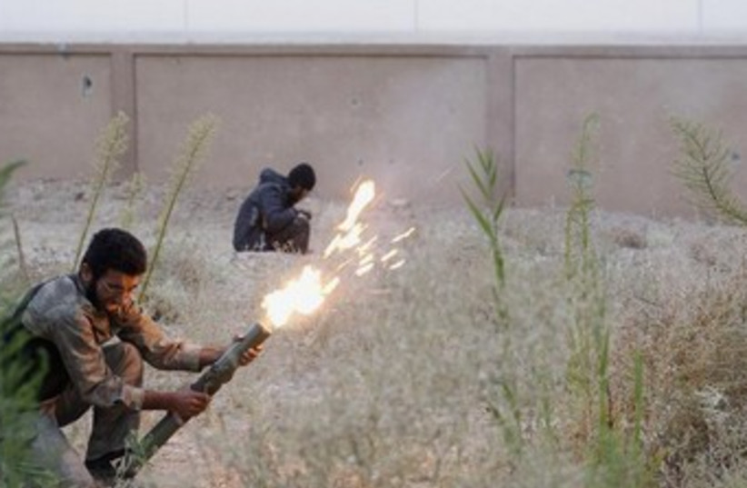 A Free Syrian Army fighter launches a rocket 370 (photo credit: REUTERS)