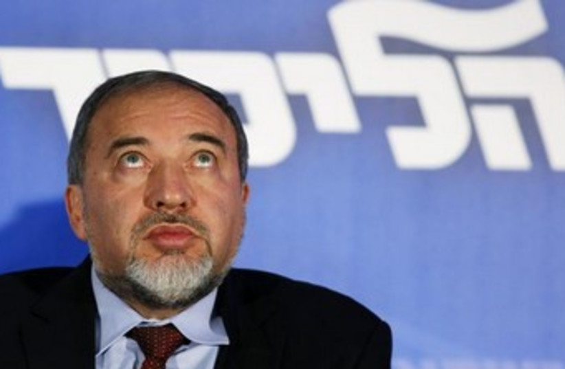 Liberman looking up under Likud sign 370 (photo credit: REUTERS/Amir Cohen)