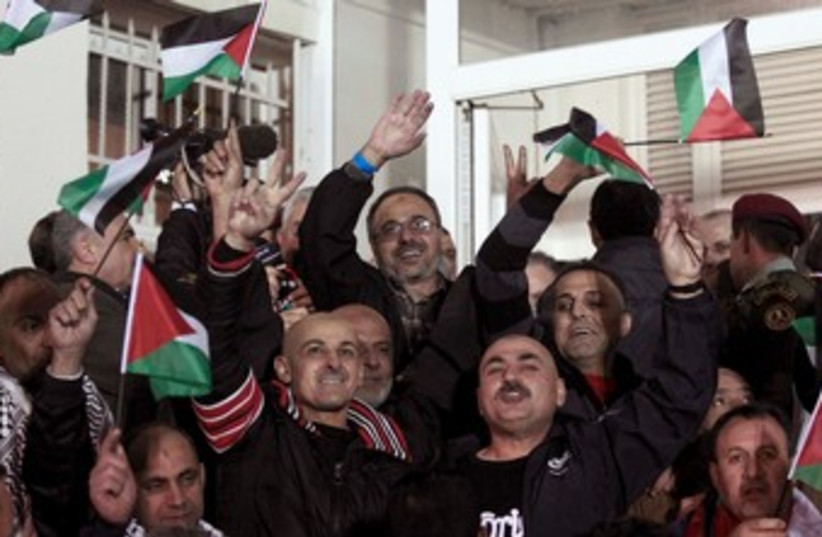 Prisoners released by Israel celebrate upon their arrival (photo credit: REUTERS)