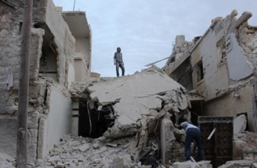 Residents inspect wreckage after Syrian army bombardment in Qatana, Aleppo. (photo credit: REUTERS/Mahmoud Hebbo)