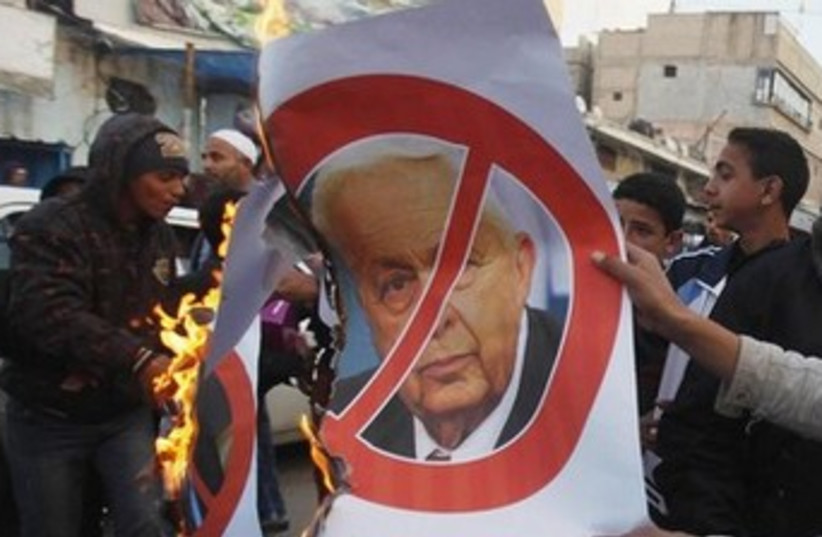 Palestinians celebrate the passing of late former Israeli Prime Minister Ariel Sharon Khan Younis, southern Gaza Strip. (photo credit:  REUTERS/Ibraheem Abu Mustafa)