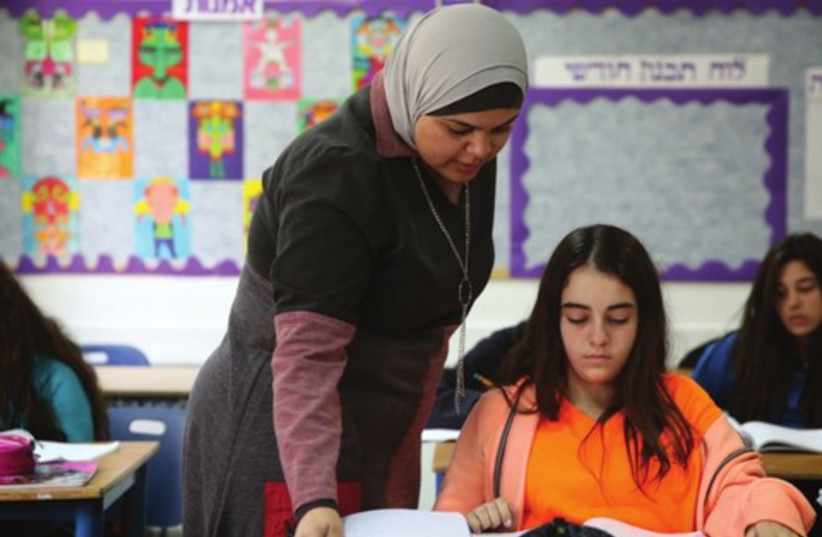 Nedaa Rabie helps a student with math at Gvanim Junior High School (photo credit: HADAS PARUSH/FLASH 90)
