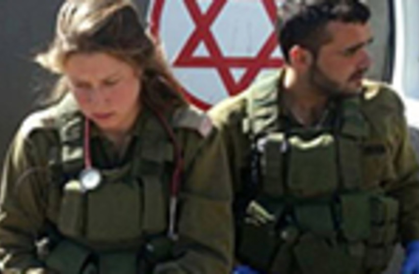 Soldiers in the IDF Medical Corps treat Syrian victims. (photo credit: COURTESY IDF SPOKESMAN'S OFFICE)