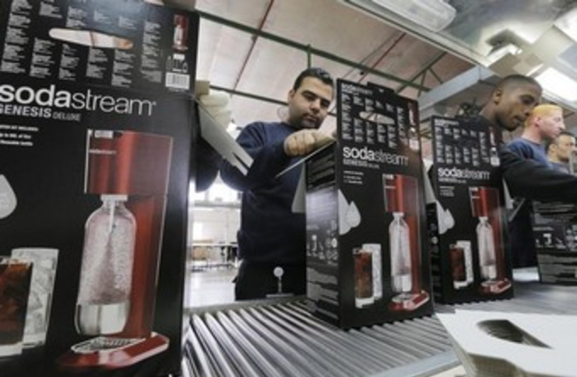 Employees pack boxes of the SodaStream product at the factory in the West Bank. (photo credit: REUTERS)