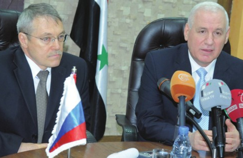 Syrian Oil Minister Suleiman al-Abbas (right) and Russian Ambassador Azmatullah Kulmohamedov in Damascus (photo credit: SANA/REUTERS)