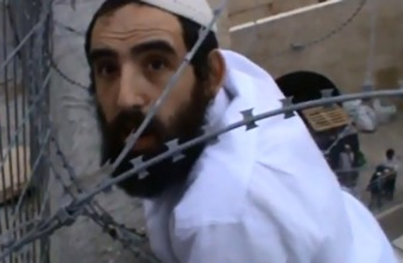 Hebron man caught in barbed wire trying to remove Palestinian flag (photo credit: YOUTUBE SCREENSHOT)