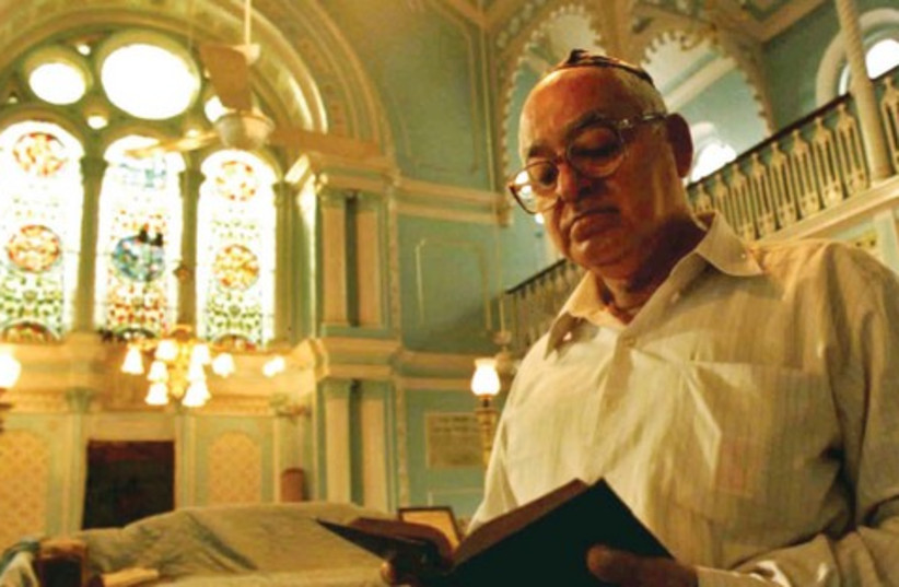 A man reads from a prayer book at a synagogue in A man reads from a prayer book at a synagogue in Bombay ombay  (photo credit: REUTERS)