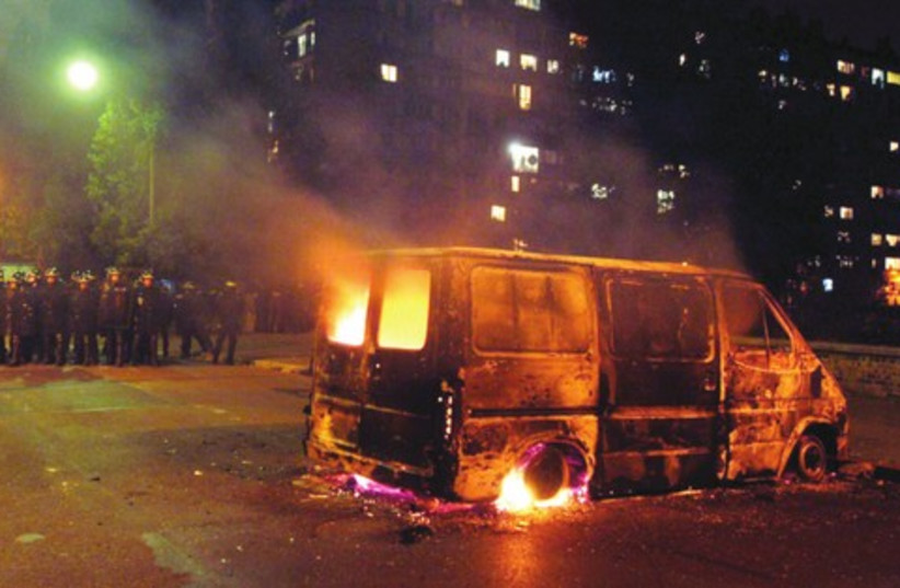 A VAN burns after clashes between French youth and riot police in the Paris suburb of Clichy (photo credit: REUTERS)