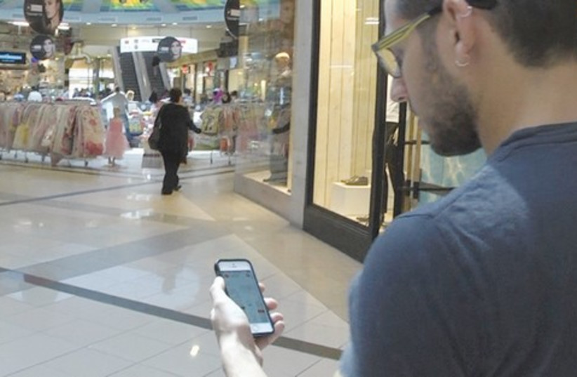 NIV ELIS watches his footsteps populate his smartphone to help navigate the Ayalon mall in Ramat Gan. (photo credit: ELI MANDELBAUM)