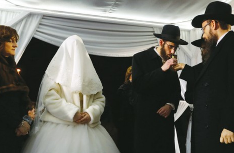 Rabbinical student Yossi Feldman tastes a ceremonial glass of wine during his wedding to Mussie Oberlander, daughter of Hungary’s leading Orthodox rabbi, in Budapest last month. (photo credit: REUTERS)