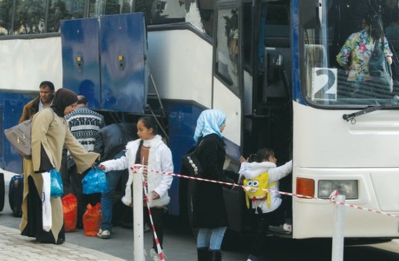 Syrian refugees put their luggage into a bus before boarding it to be transported to Beirut international airport for resettlement in Germany, joining about 300 Syrian refugees that departed early Tuesday morning. (photo credit: REUTERS)