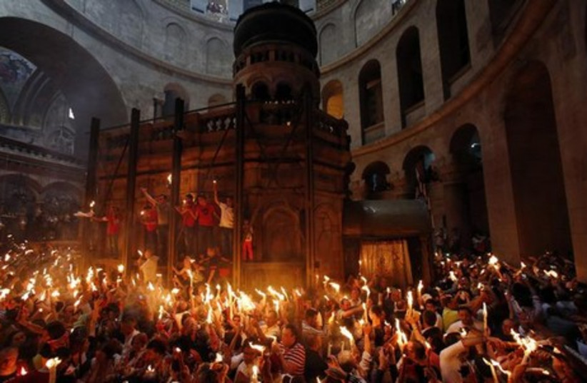 Worshippers take part in the Christian Orthodox Holy Fire ceremony at the Church of the Holy Sepulchre in Jerusalem. (photo credit: REUTERS)