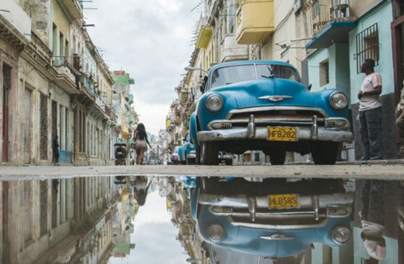 A STREET in Havana is reflected in a collection of water (photo credit: BENNY LEVIN PHOTOGRAPHY)