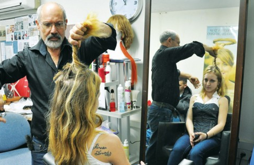 Model Katia Marshvin has her locks cut by Eli Ben-Zikri to use as a wig while she undergoes treatment. (photo credit: Courtesy)