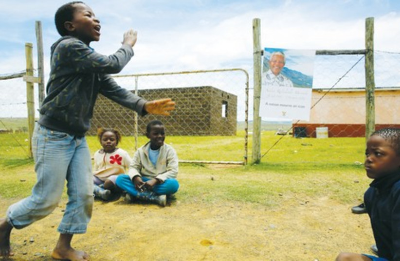CHILDREN PLAY at the perimeter of former South African president Nelson Mandela’s property in Qunu, in December 2013. (photo credit: REUTERS)